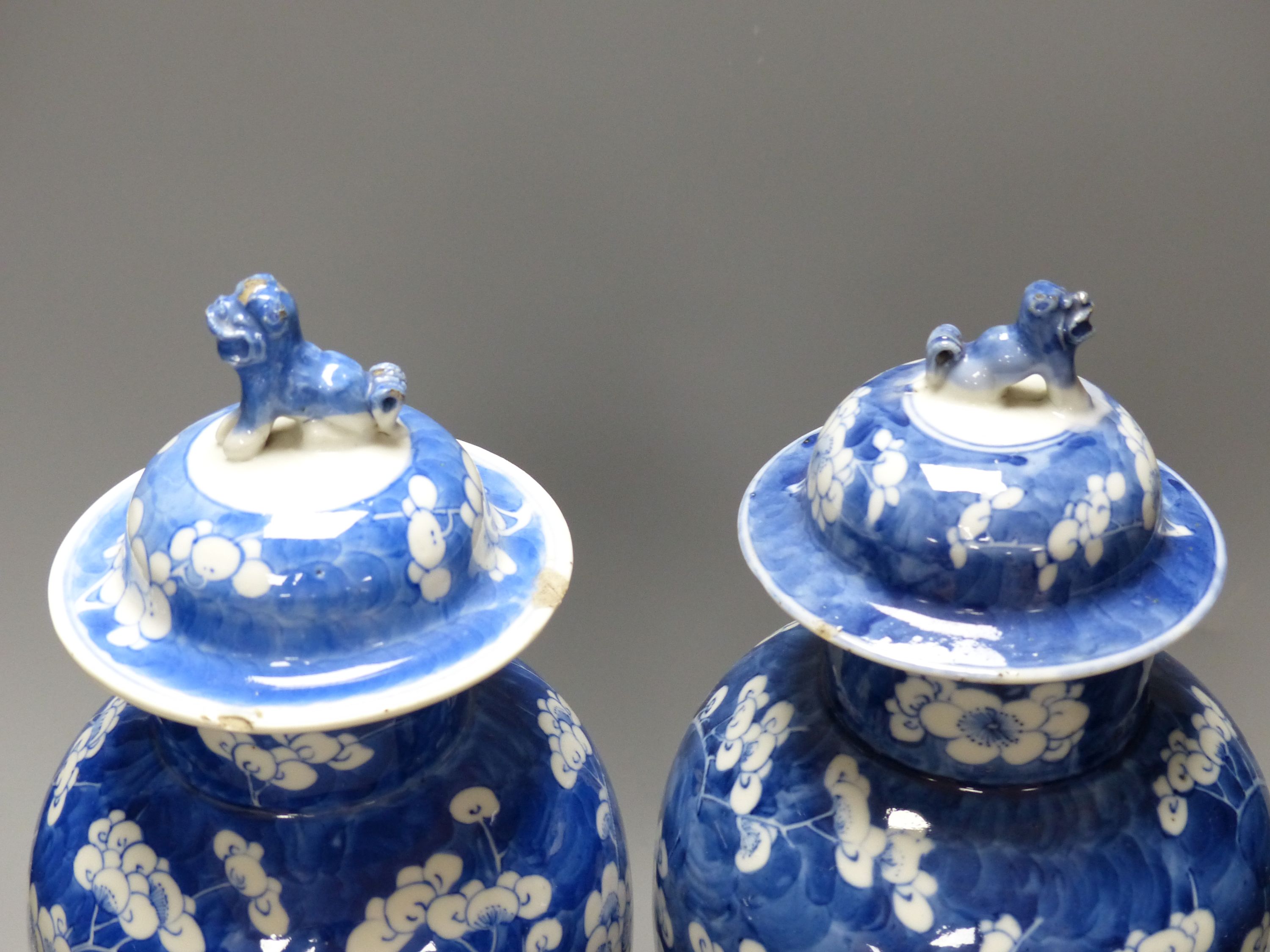 A pair of 19th century Chinese blue and white prunus vases and covers, height 38cm, a Kangxi marks